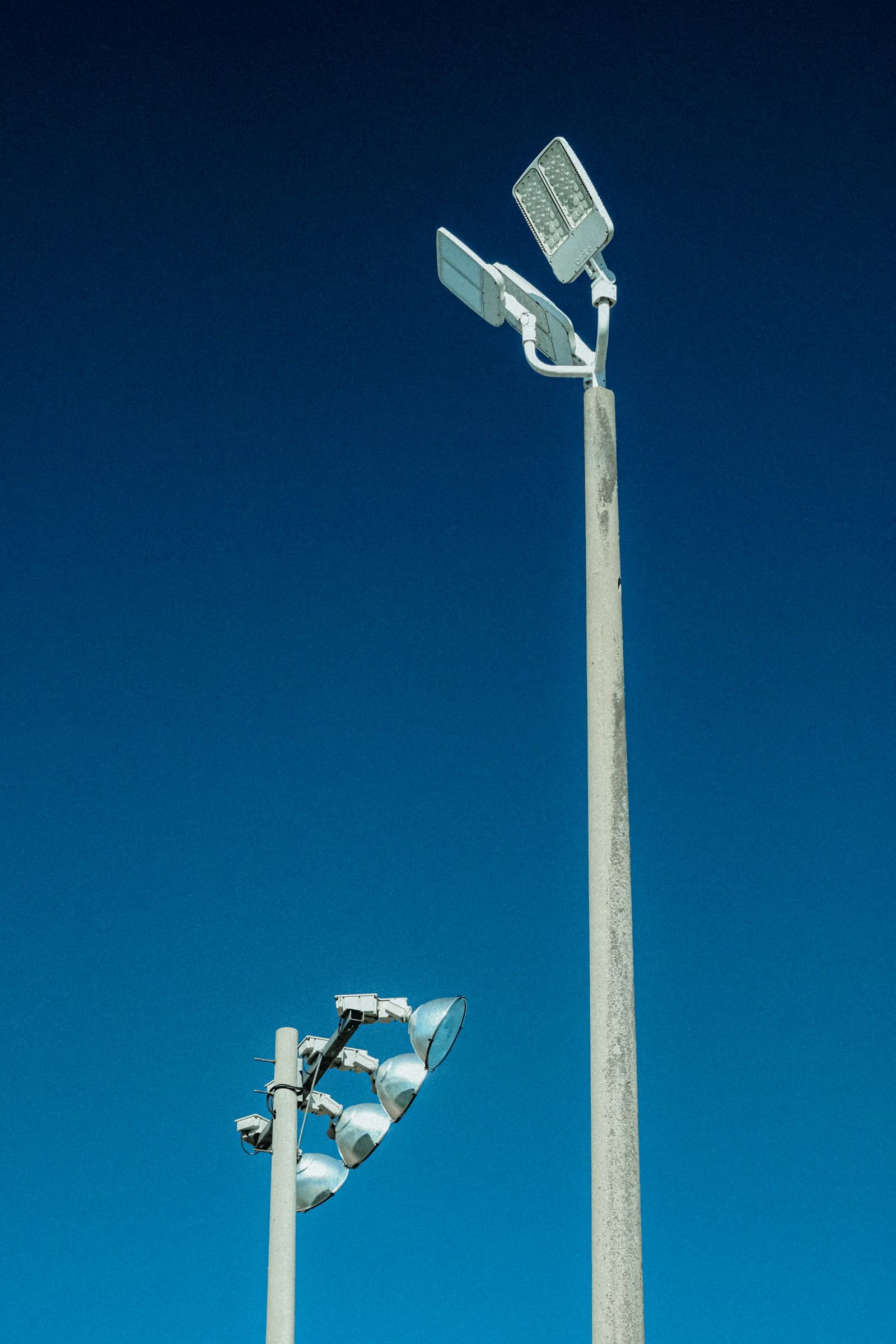 Torres de iluminación de estadio sobre un cielo azul
